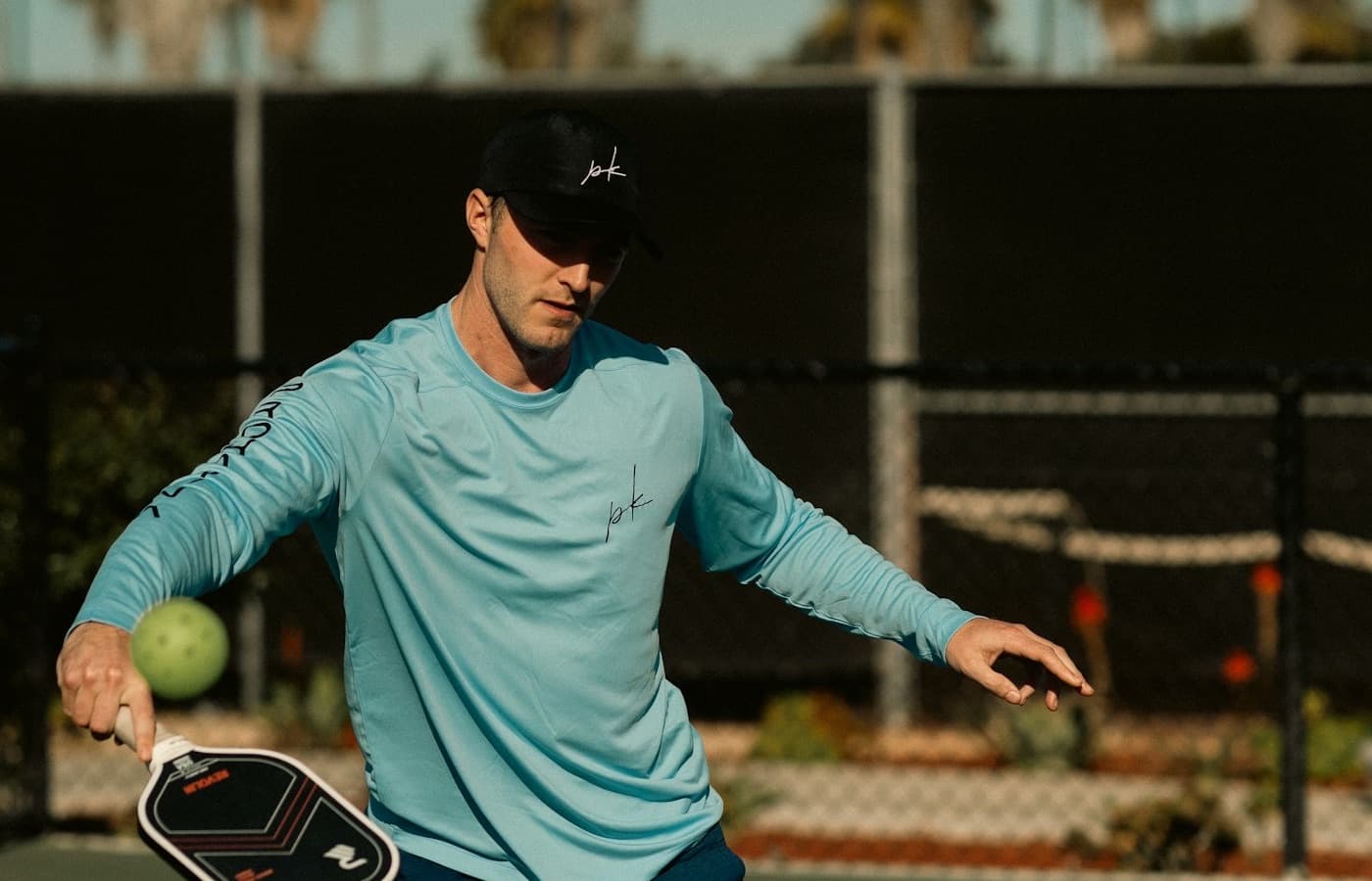 Solo player returning a pickleball near the net on an outdoor court