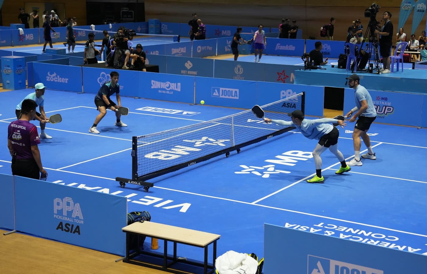 Doubles partners discussing the score between points on an indoor court